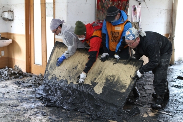 Photo: Volunteers from PBV clear mud and debris from homes in Ishinomaki, Japan. (Ueno Yoshinori)